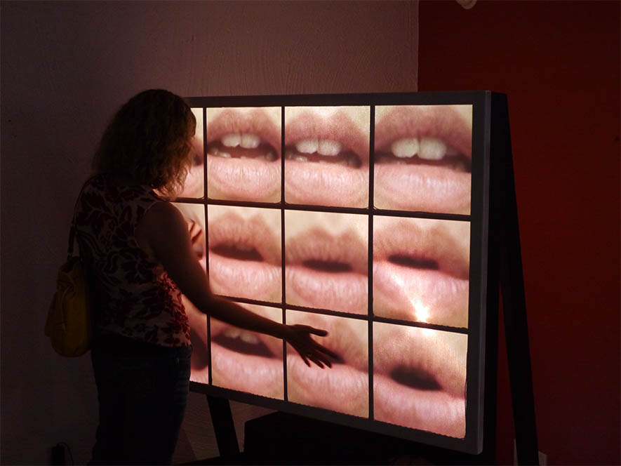 Female using a touch screen monitor with collage of lips on screen
