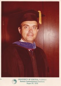 A person in academic regalia with a yellow tassel poses for a portrait. Text below reads "University of Central Florida Summer Commencement Ceremony August 24, 1979.