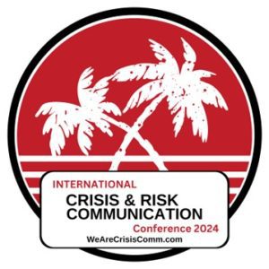 Logo for the International Crisis & Risk Communication Conference 2024, featuring palm trees and a red background, with the website WeAreCrisisComm.com.