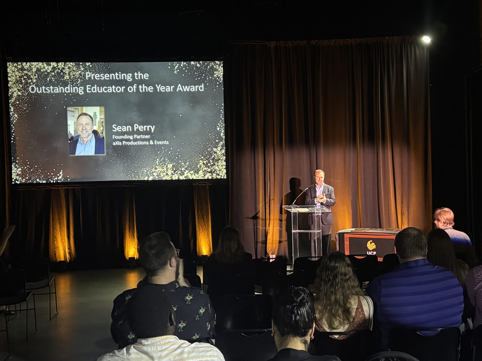 Sean Perry on stage preparing to announce the Educator of the Year.